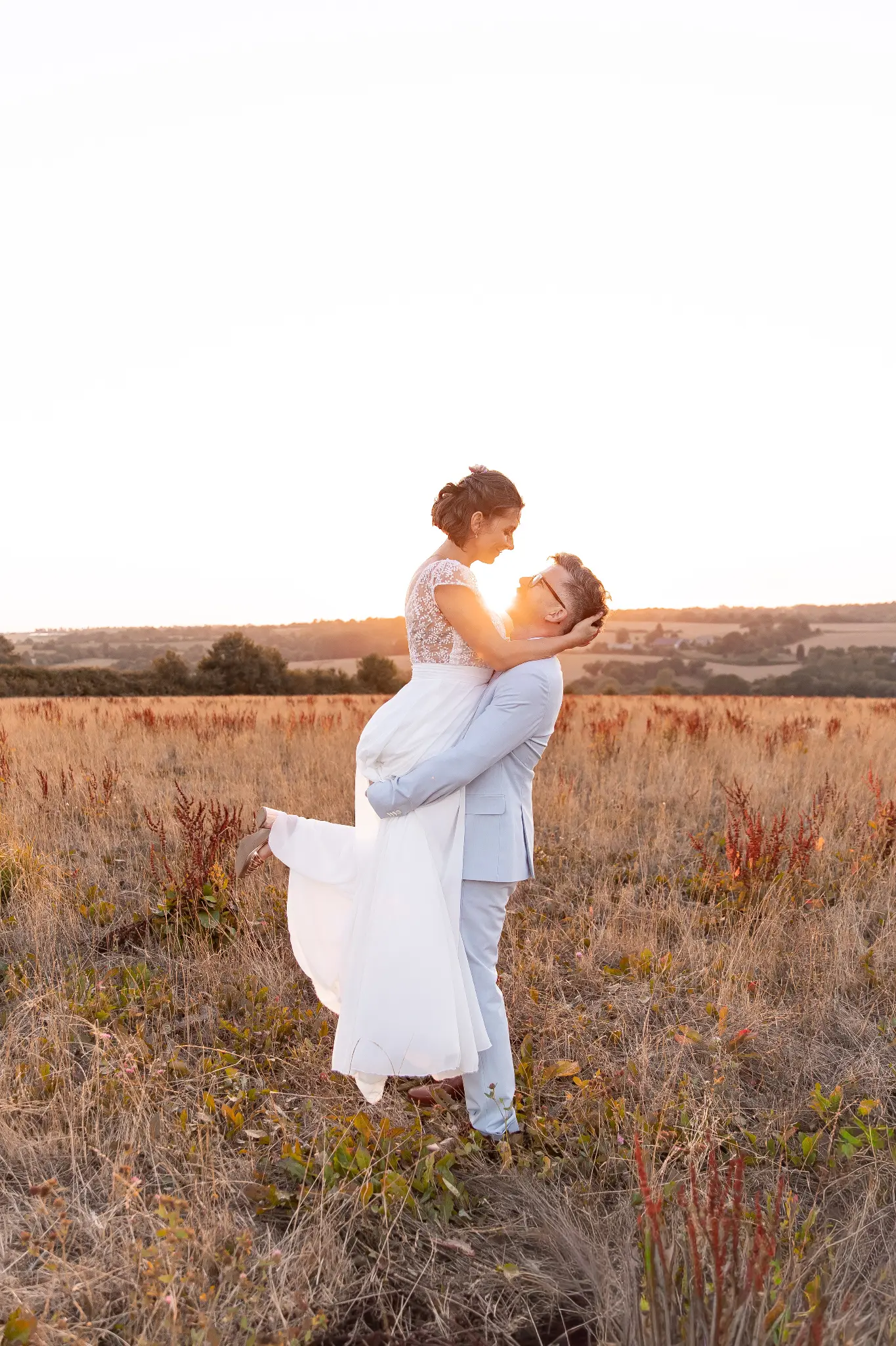 Mariés et famille dans un champ breton à la lumière du coucher de soleil